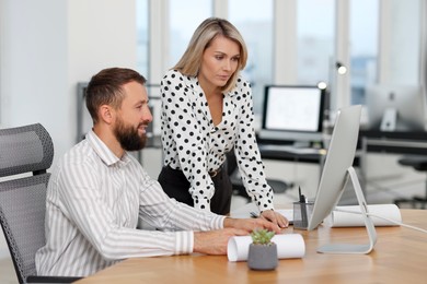 Photo of Technicians making digital engineering drawing on computer at desk in office