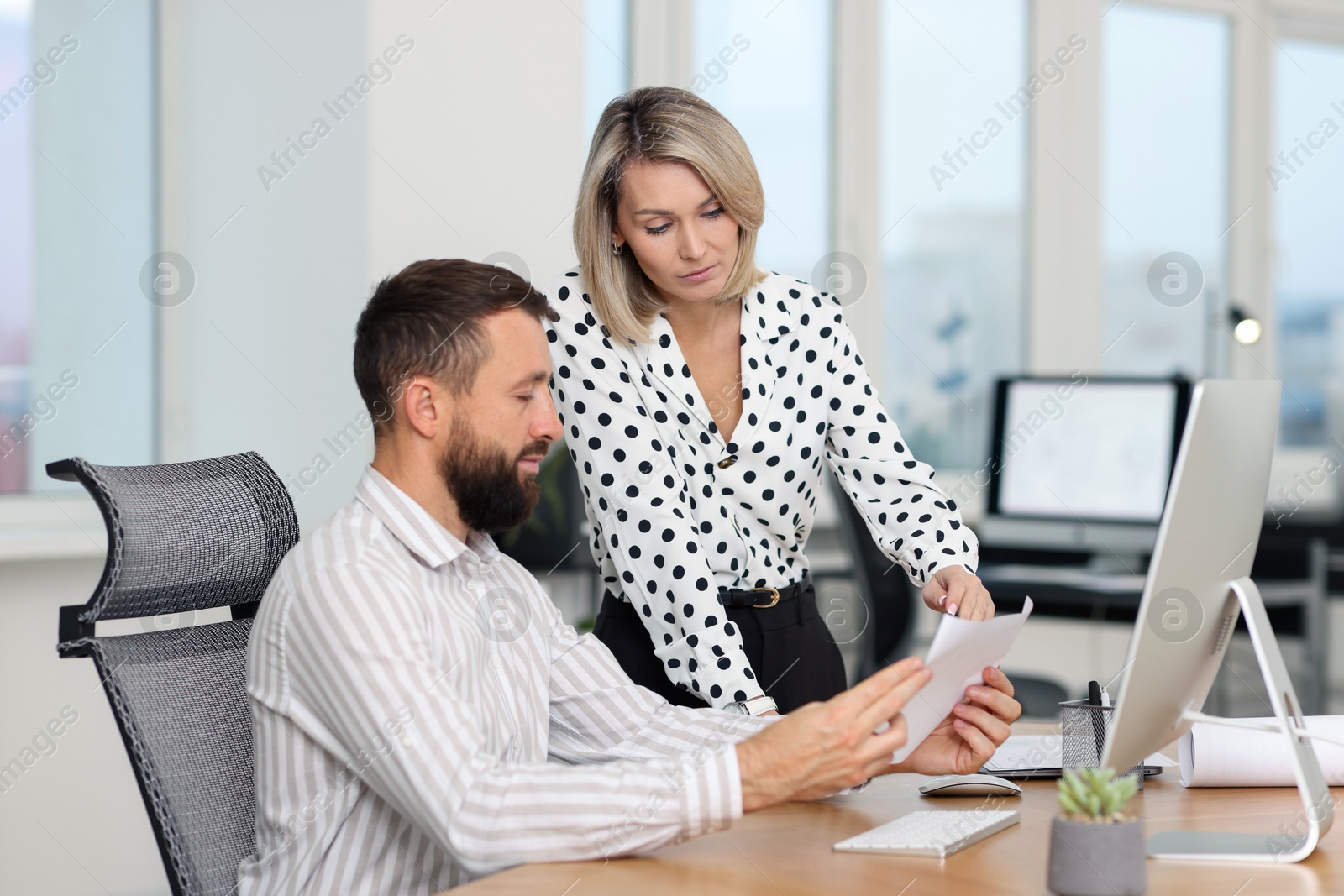 Photo of Technicians making digital engineering drawing on computer at desk in office