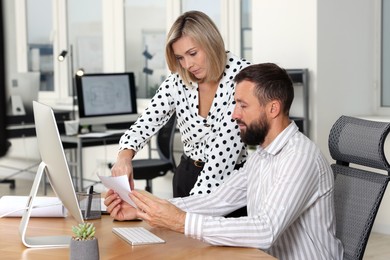 Photo of Technicians making digital engineering drawing on computer at desk in office