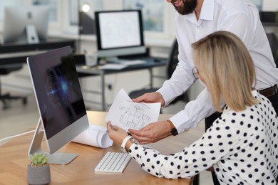 Photo of Technicians making digital engineering drawing on computer at desk in office