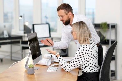 Photo of Technicians making digital engineering drawing on computer at desk in office