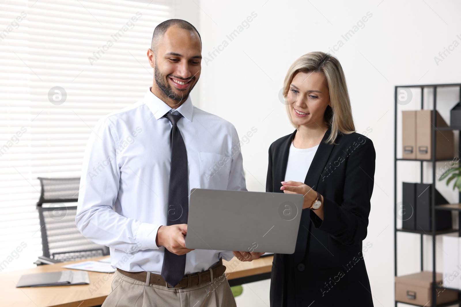 Photo of Coworkers with laptop working together in office