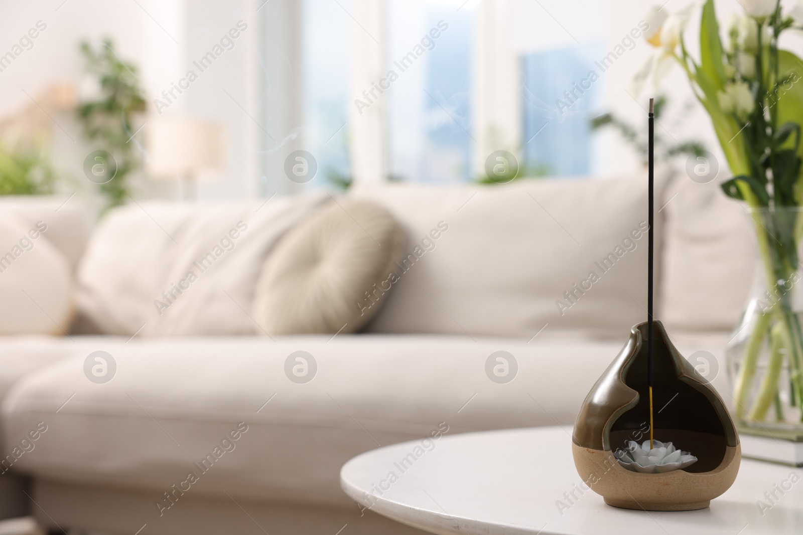 Photo of Feng shui. Incense stick in holder on white table indoors, closeup. Space for text