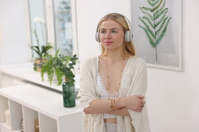 Photo of Feng shui. Young woman with headphones listening to music at home