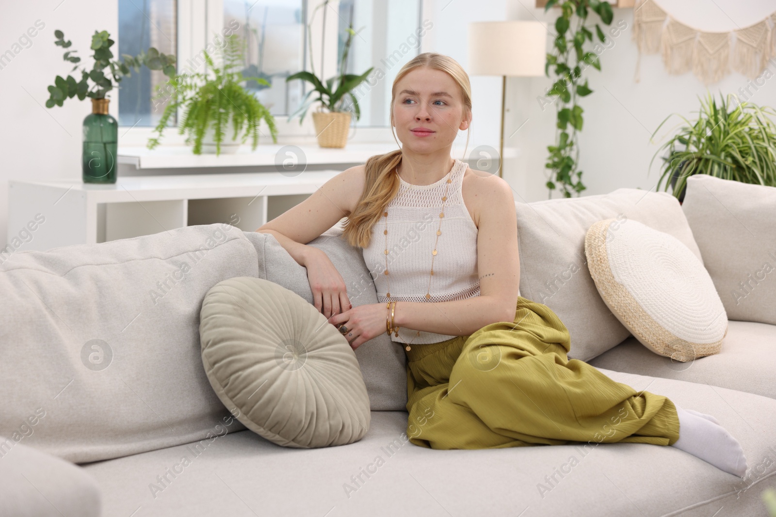 Photo of Feng shui. Young woman sitting on couch at home