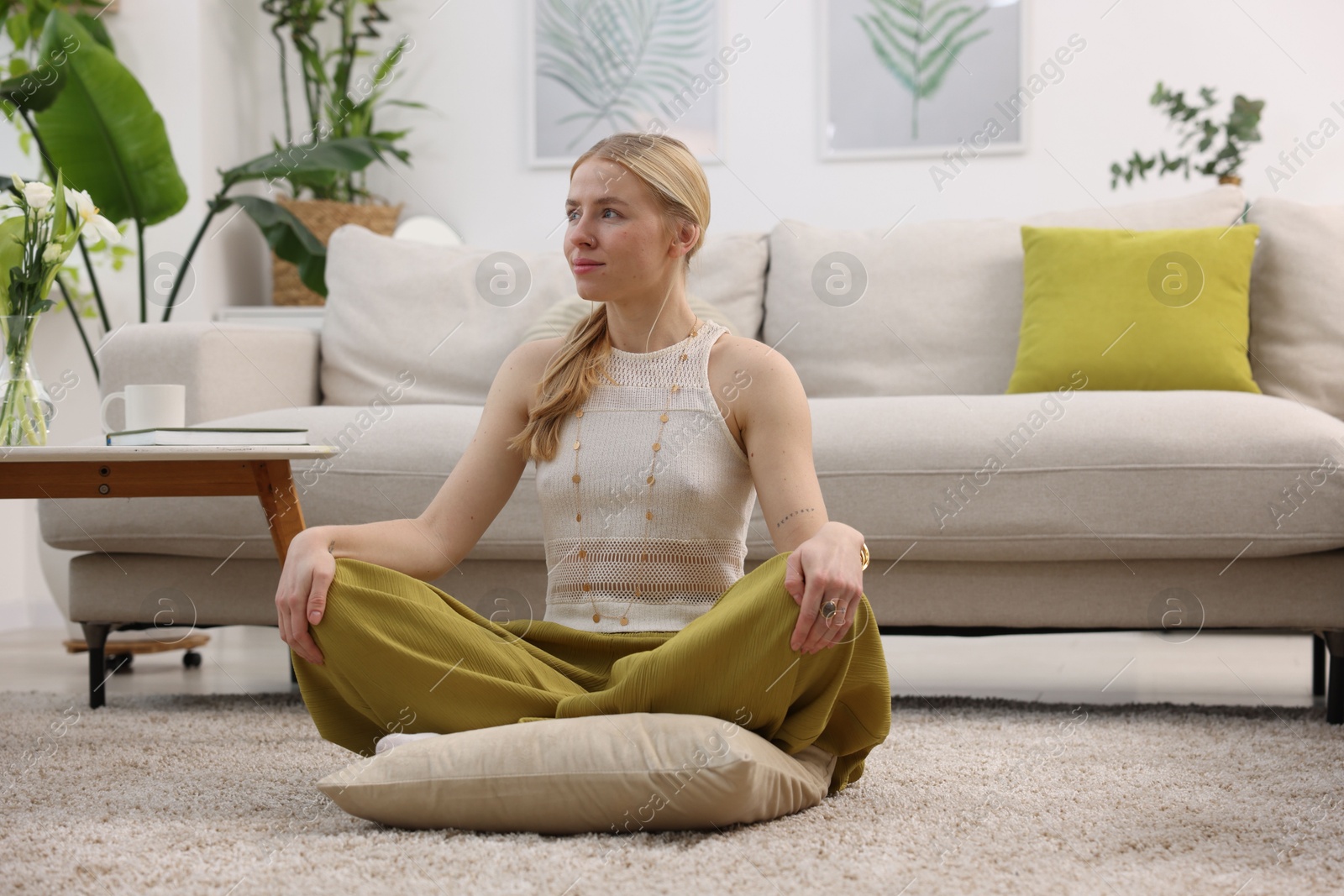 Photo of Feng shui. Young woman meditating on floor at home