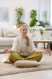 Photo of Feng shui. Young woman meditating on floor at home