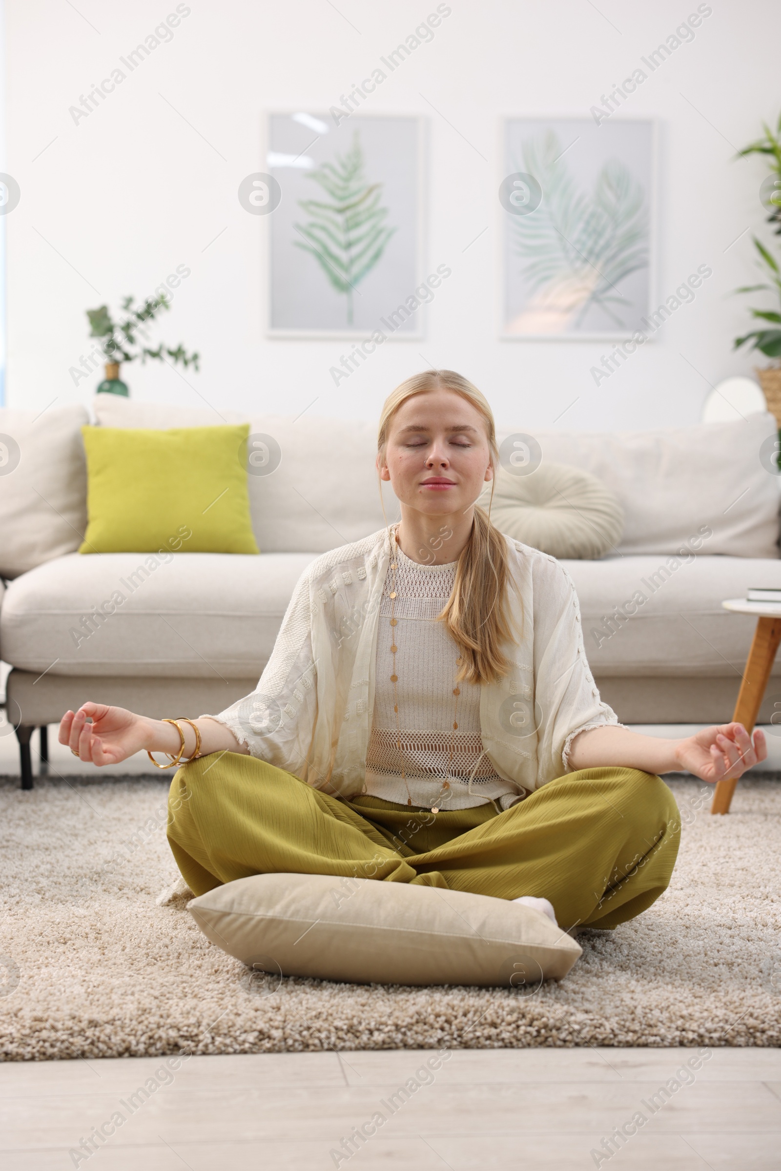 Photo of Feng shui. Young woman meditating on floor at home