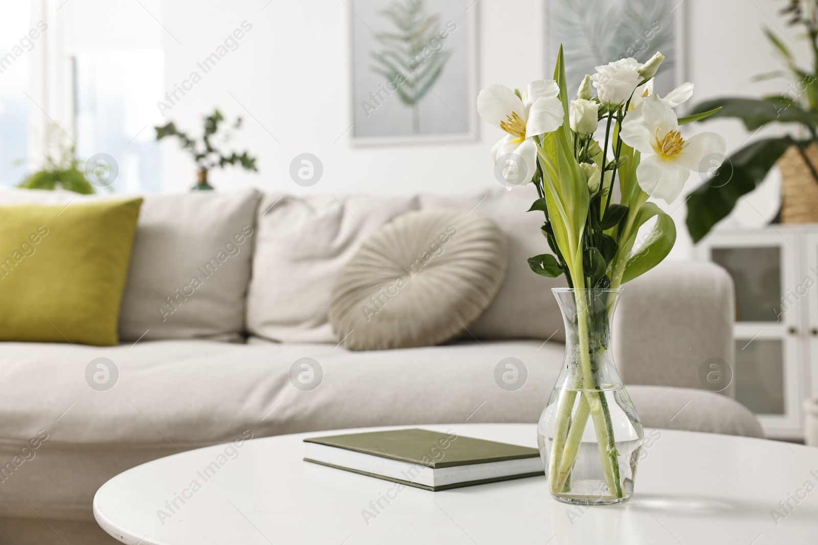 Photo of Feng shui. Vase with flowers and book on white table indoors. Space for text