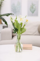 Photo of Feng shui. Vase with flowers and book on white table indoors