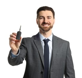 Photo of Cheerful salesman with car key on white background