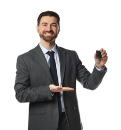 Photo of Cheerful salesman showing car key on white background