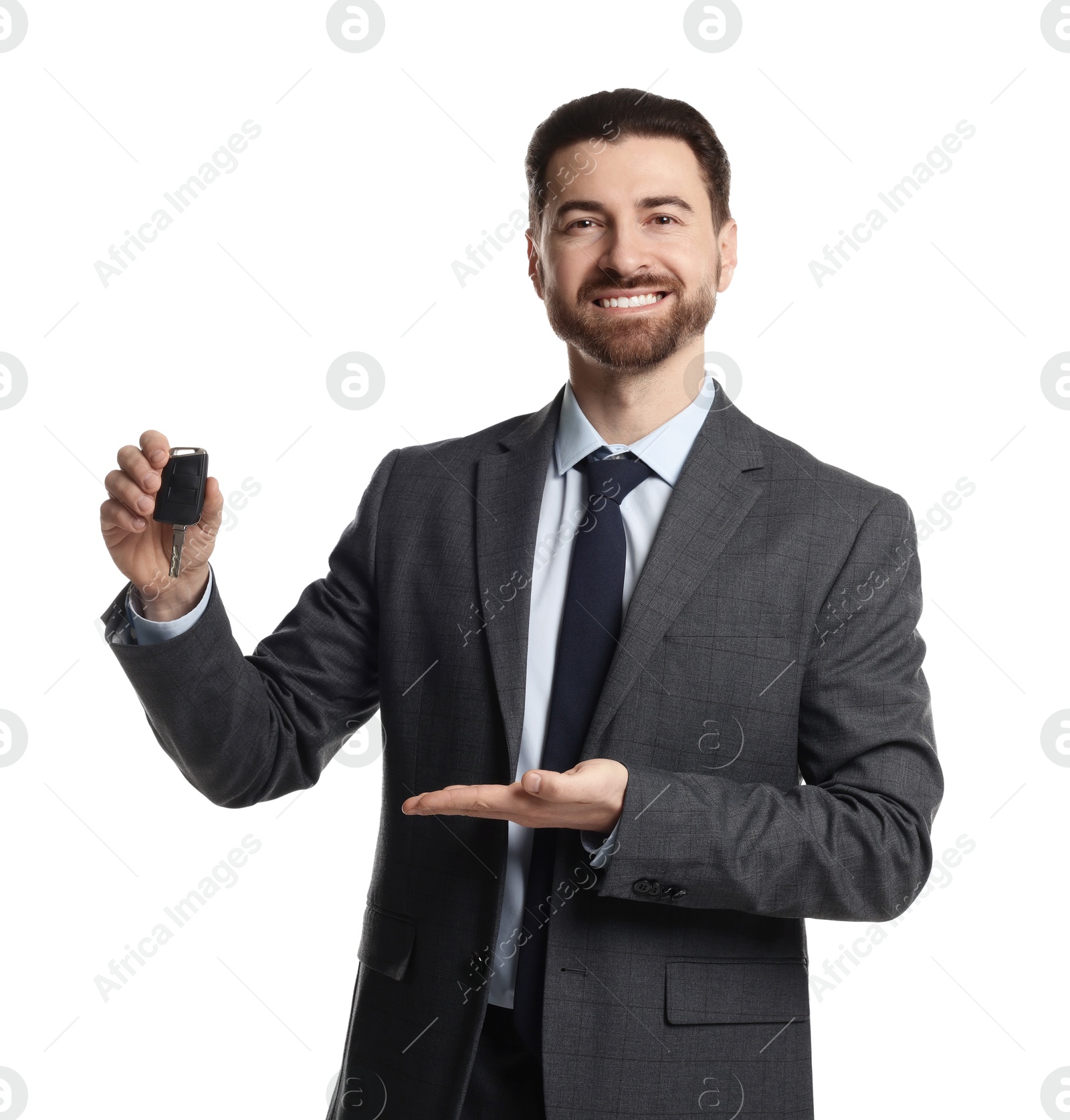 Photo of Cheerful salesman showing car key on white background