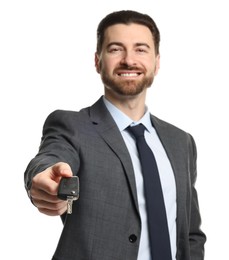 Photo of Cheerful salesman with car key on white background