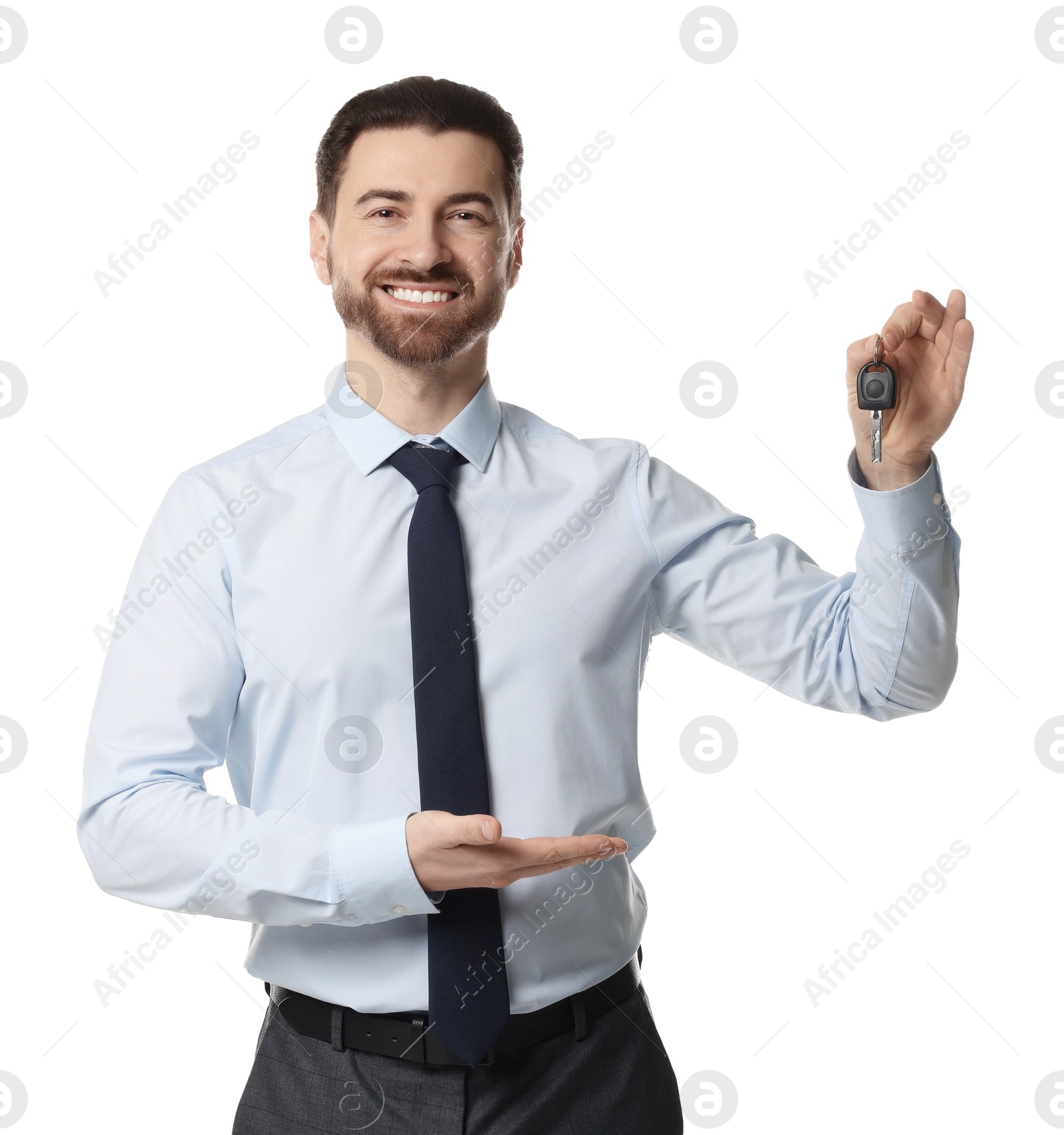 Photo of Cheerful salesman with car key on white background