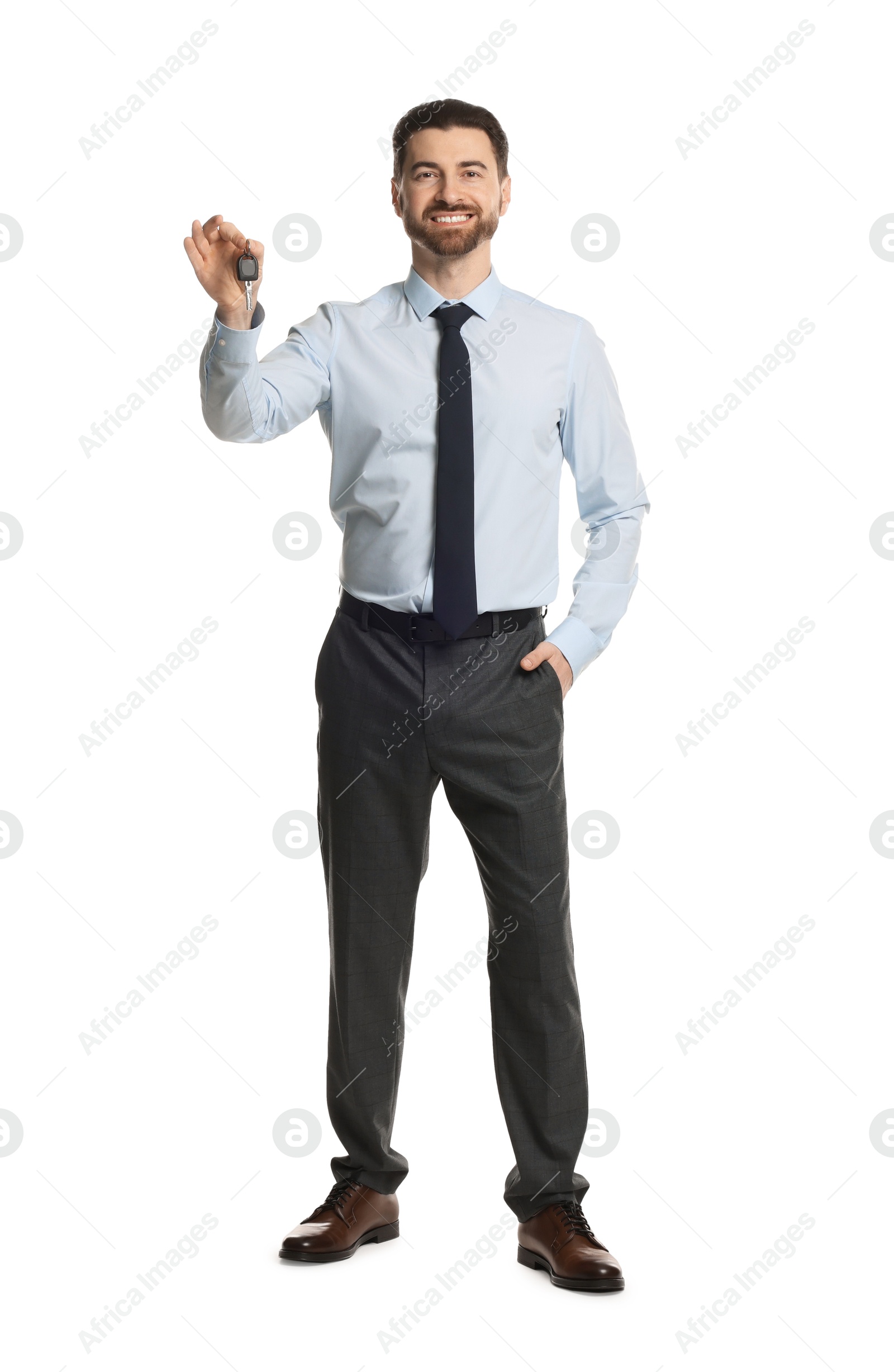 Photo of Cheerful salesman with car key on white background