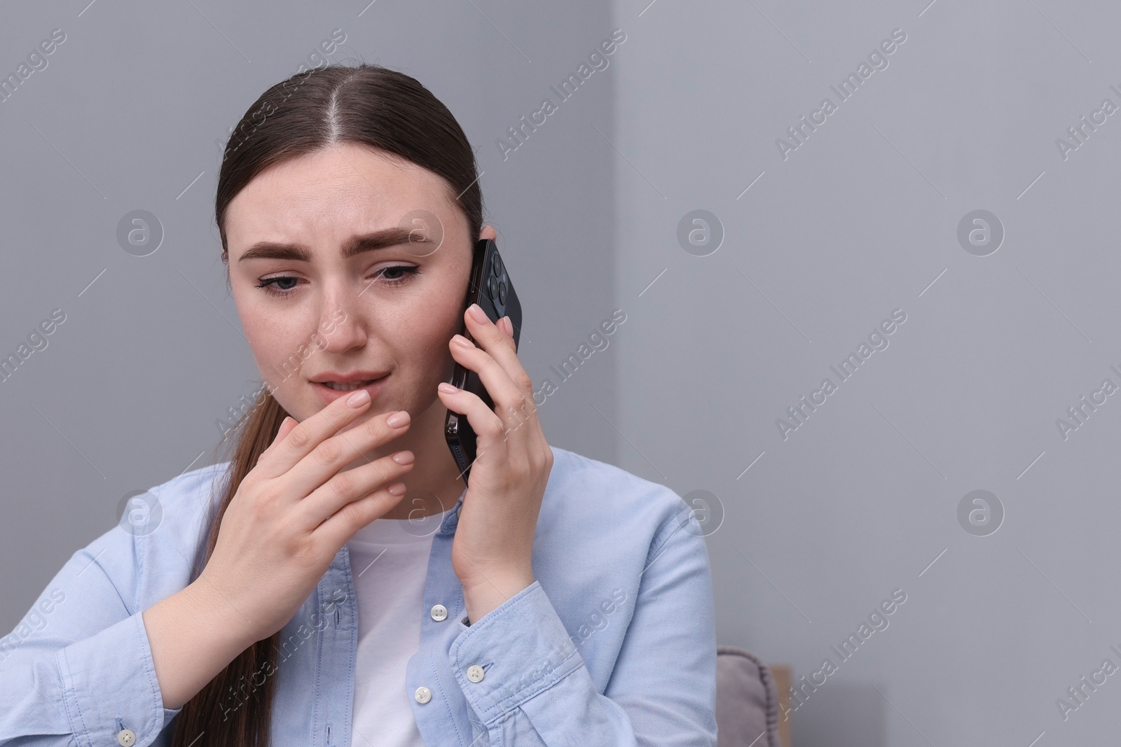 Photo of Stressed woman calling hotline for mental health help at home. Space for text