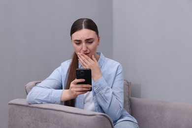 Photo of Stressed woman calling hotline for mental health help in armchair at home