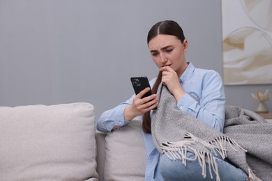 Photo of Depressed woman calling hotline for mental health help on sofa at home. Space for text