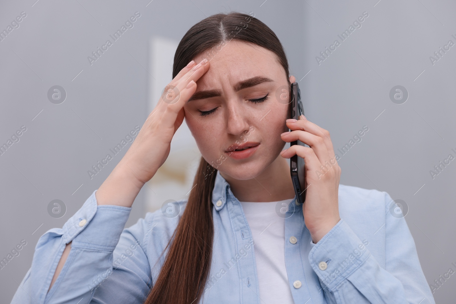 Photo of Stressed woman calling hotline for mental health help at home