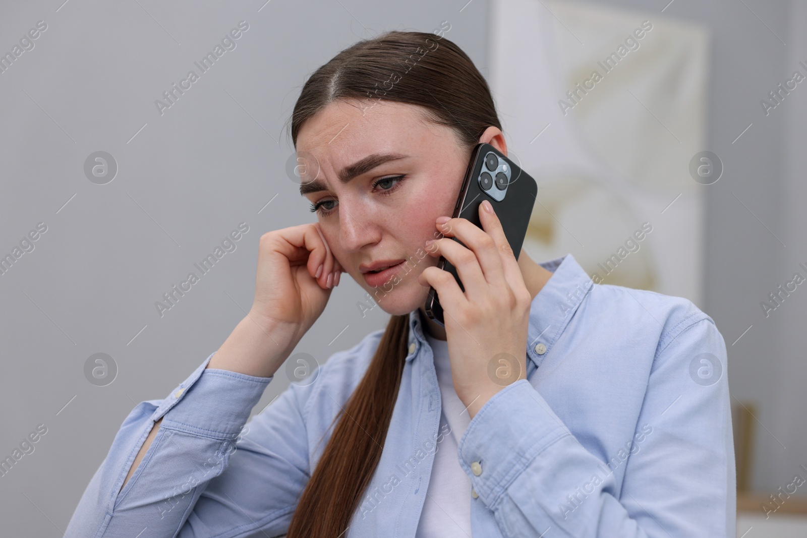 Photo of Stressed woman calling hotline for mental health help at home