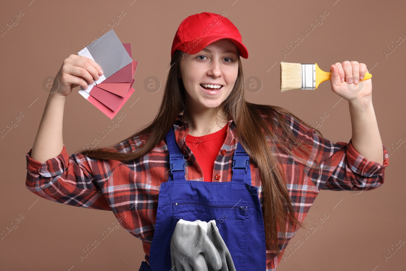 Photo of Professional painter with brush and color samples on brown background