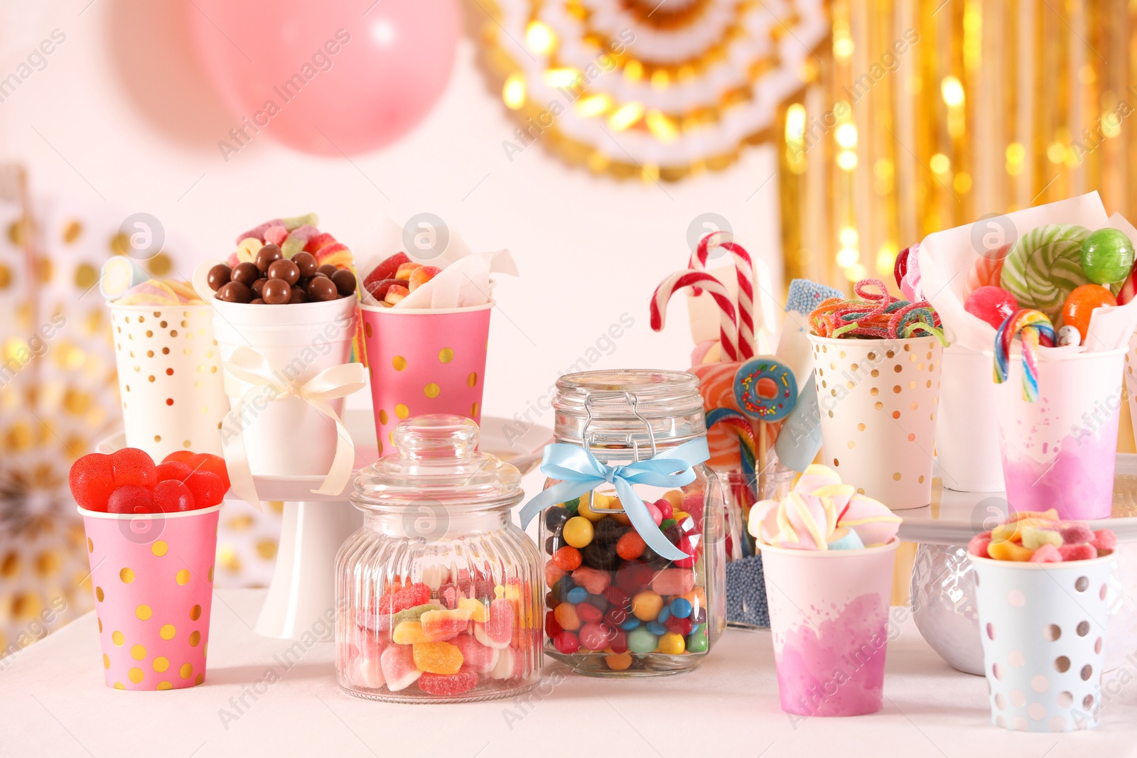 Photo of Candy bar. Many different sweets on table in festive decorated room