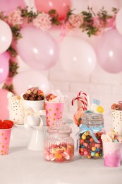 Photo of Candy bar. Many different sweets on table in festive decorated room