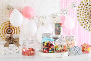 Photo of Candy bar. Many different sweets on white wooden table in festive decorated room