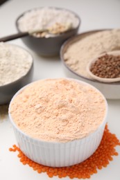 Photo of Different types of flour on white table, closeup