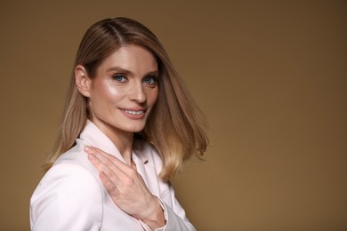 Photo of Portrait of beautiful happy woman with straight blonde hair on light brown background, space for text