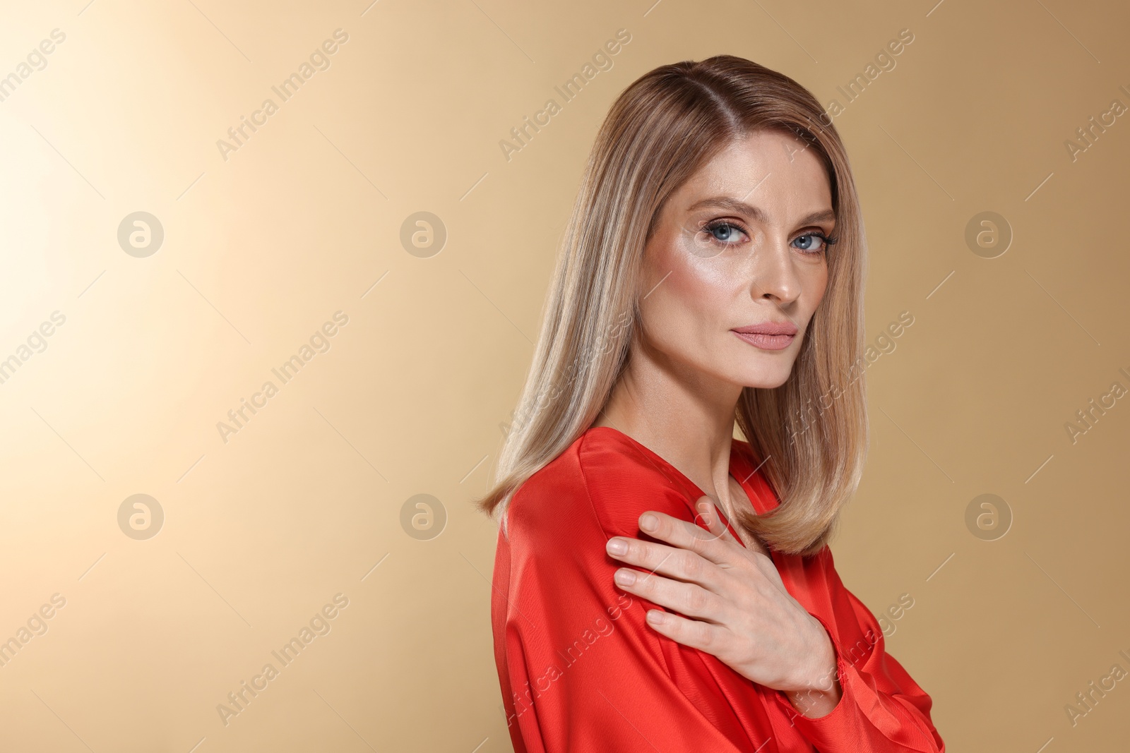 Photo of Portrait of beautiful woman with straight blonde hair on beige background, space for text