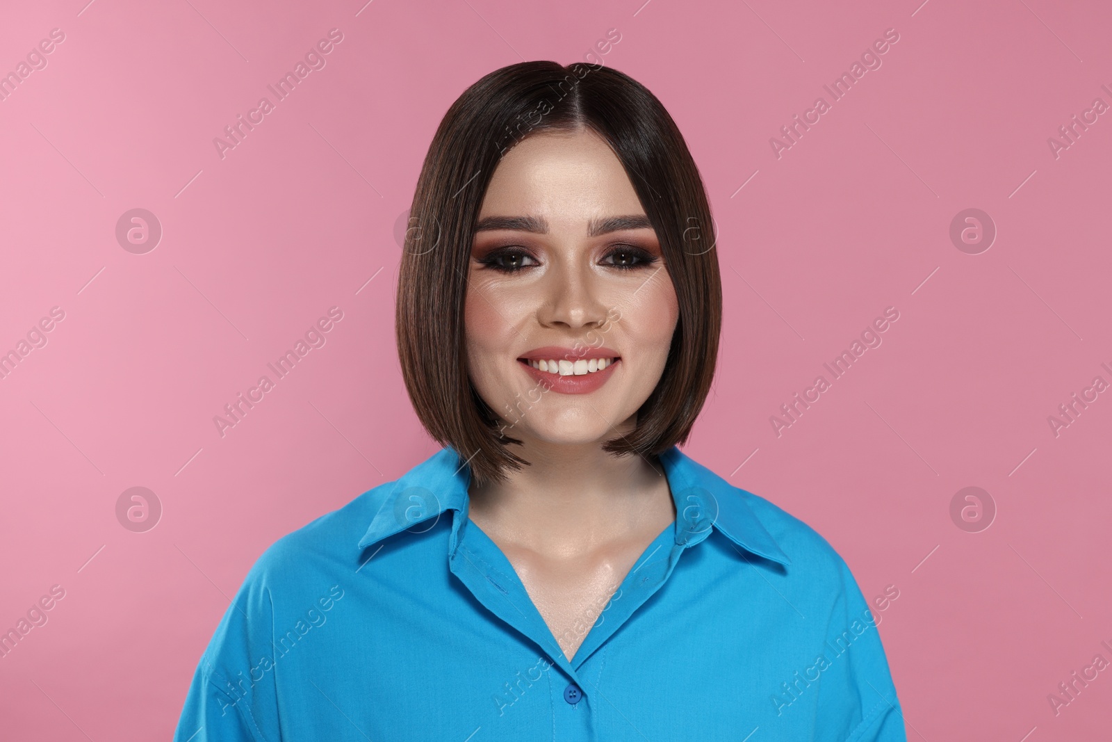 Photo of Portrait of beautiful young happy woman with gorgeous straight hair on pink background