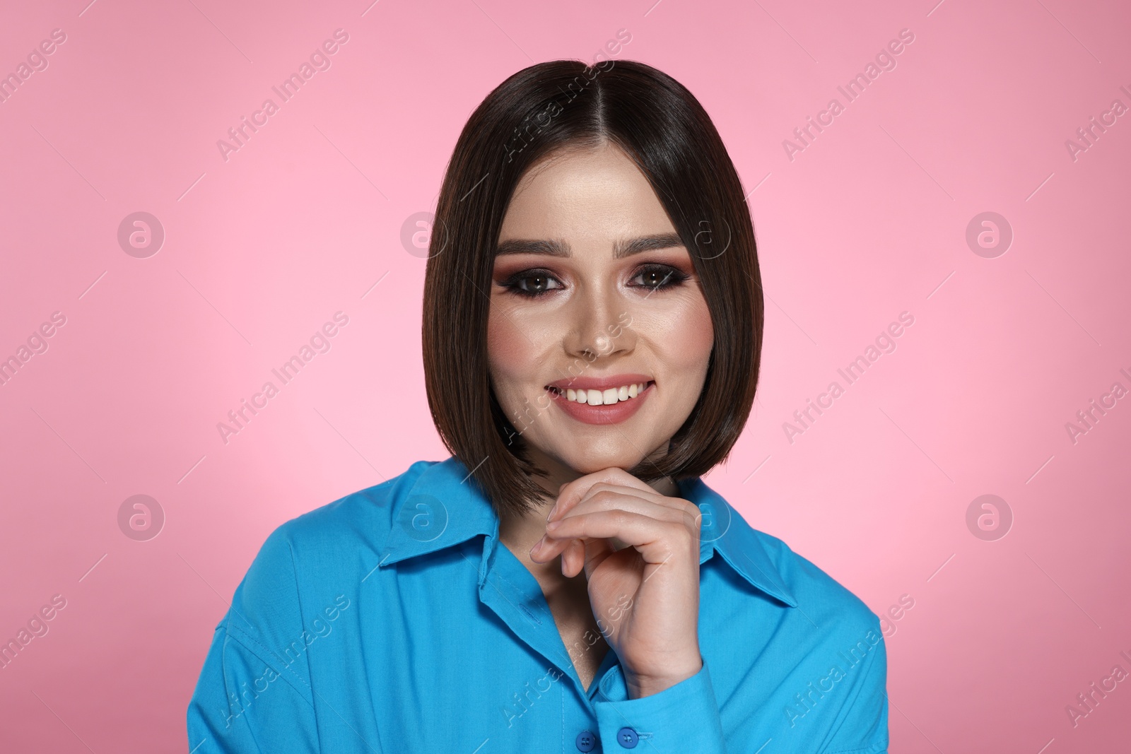 Photo of Portrait of beautiful young happy woman with gorgeous straight hair on pink background