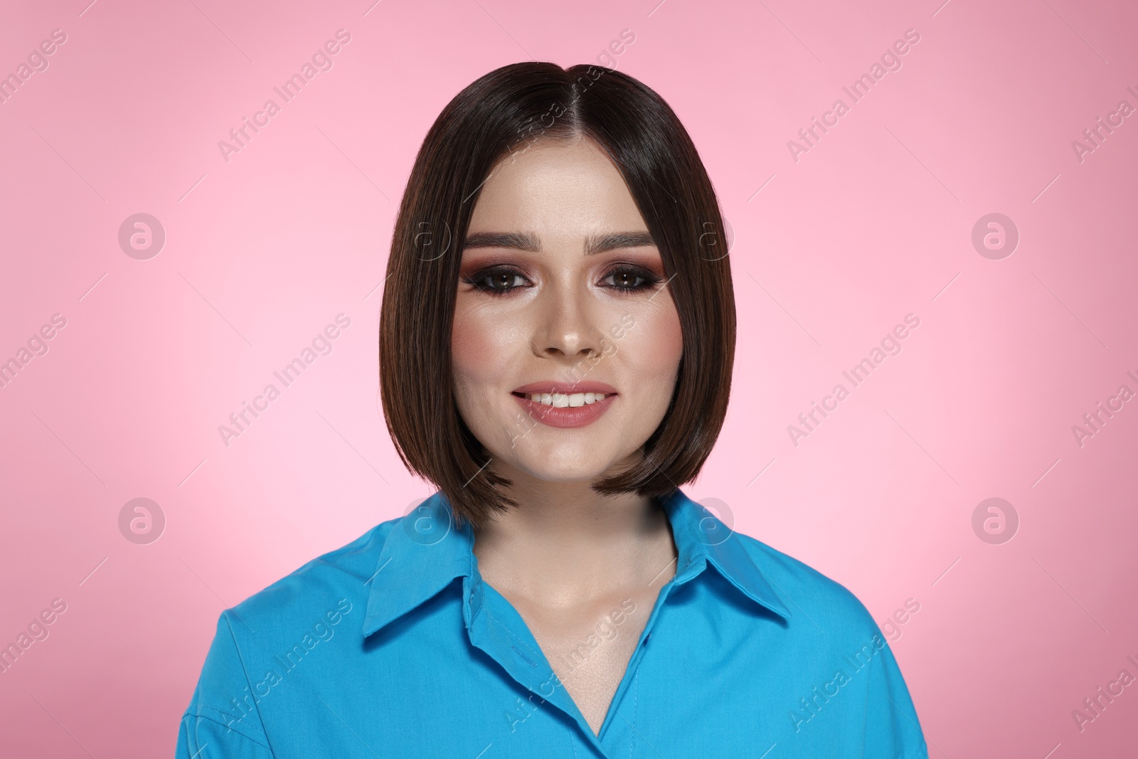 Photo of Portrait of beautiful young happy woman with gorgeous straight hair on pink background