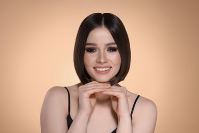 Photo of Portrait of beautiful young happy woman with gorgeous straight hair on beige background