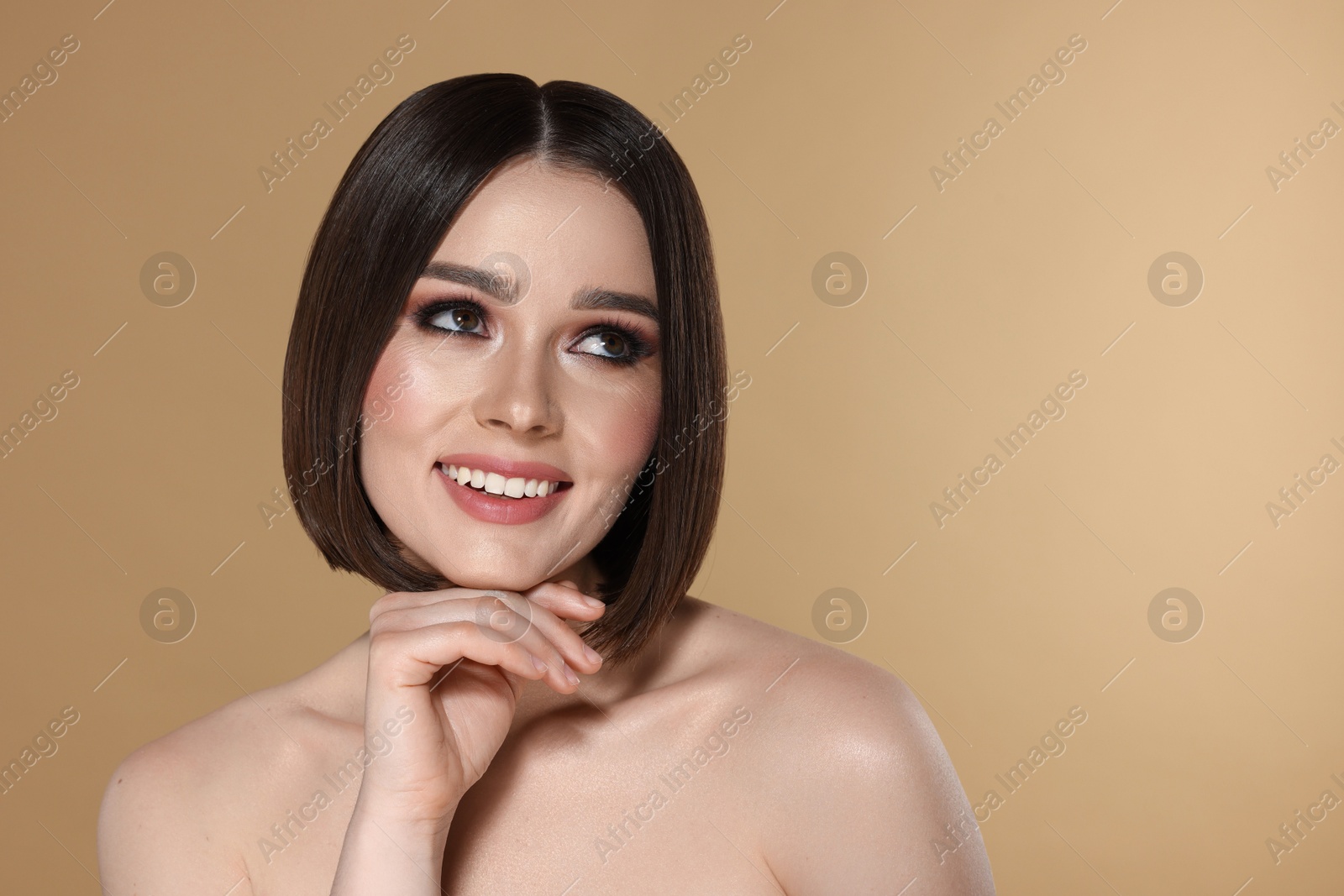 Photo of Portrait of beautiful young happy woman with gorgeous straight hair on beige background, space for text