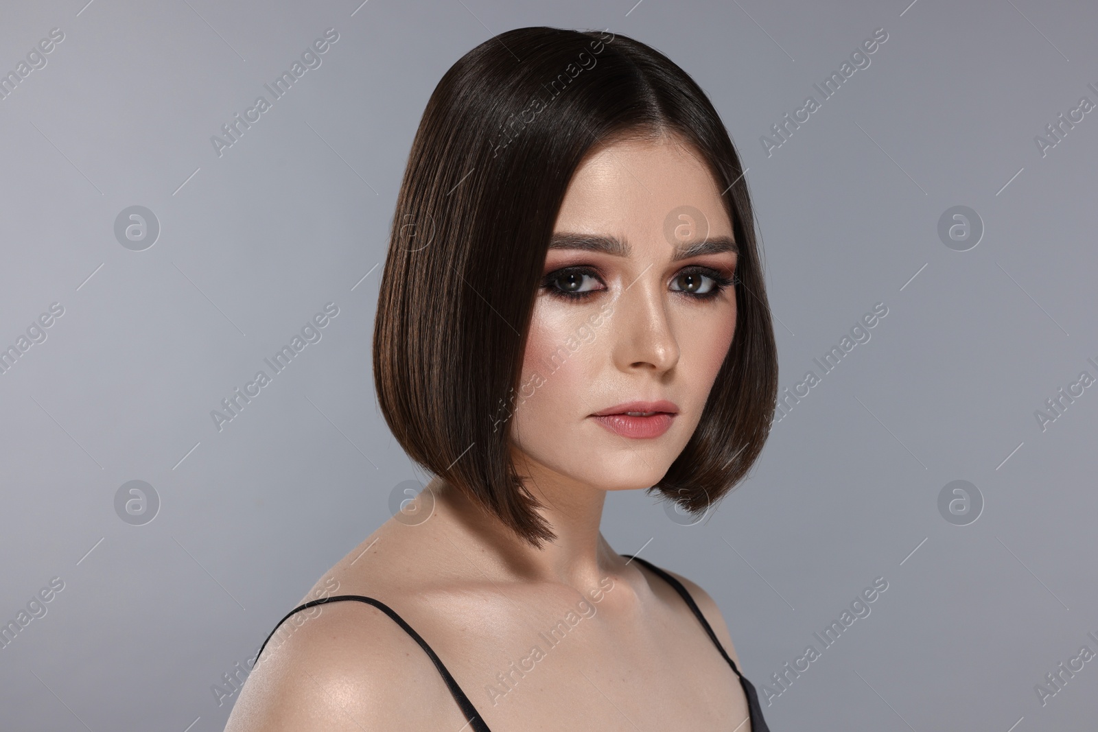 Photo of Portrait of beautiful young woman with gorgeous straight hair on light grey background