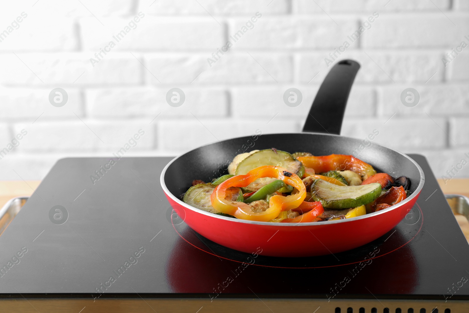 Photo of Frying pan with vegetables and mushrooms on stove indoors, closeup