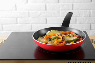 Photo of Frying pan with vegetables and mushrooms on stove indoors, closeup