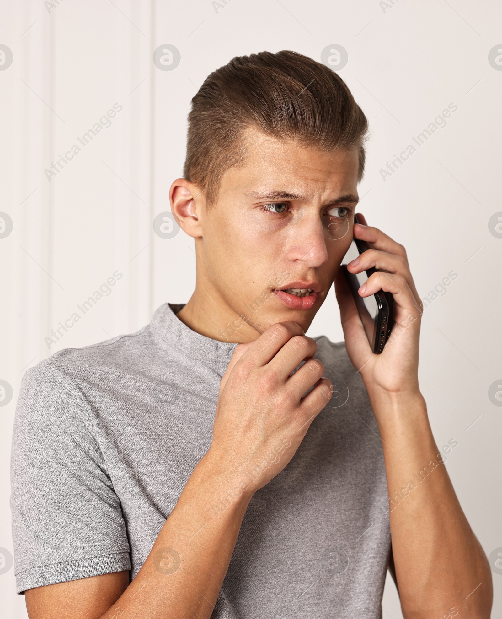 Photo of Stressed man calling hotline for mental health help indoors