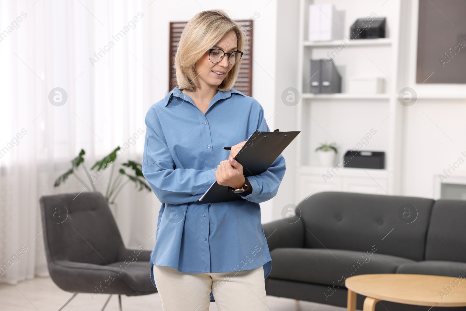 Photo of Professional psychologist with clipboard in modern office