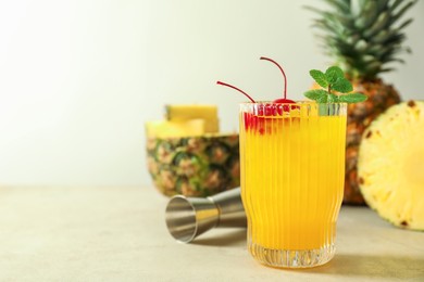 Photo of Tasty pineapple cocktail with mint and cherry in glass served on light table, space for text