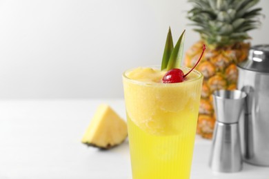 Photo of Tasty pineapple cocktail with cherry in glass on light table, closeup. Space for text