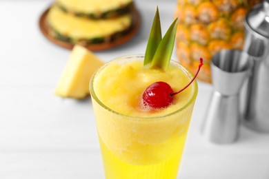 Photo of Tasty pineapple cocktail with cherry in glass on light table, closeup