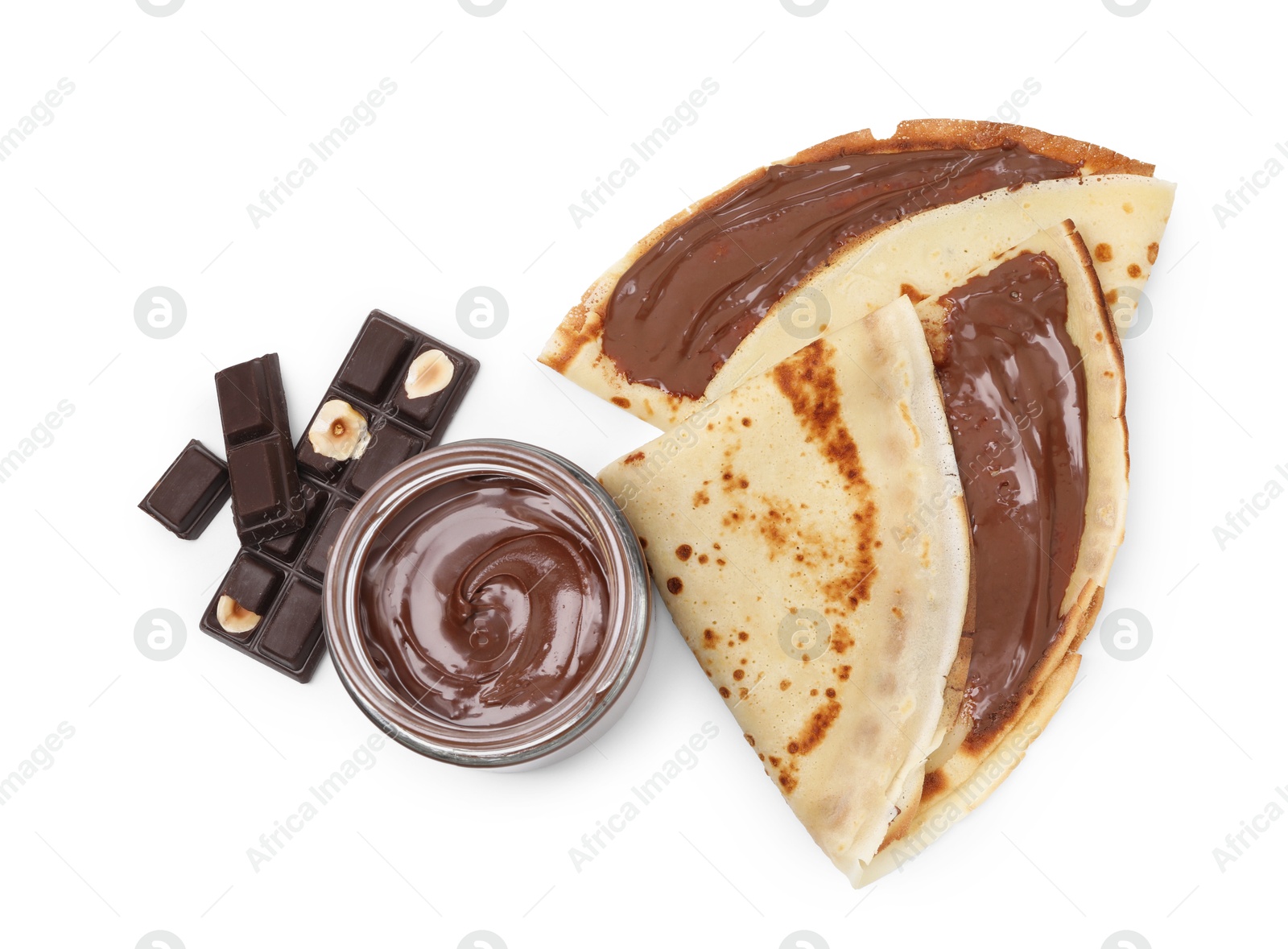 Photo of Tasty crepes with chocolate butter and pieces of chocolate isolated on white, top view