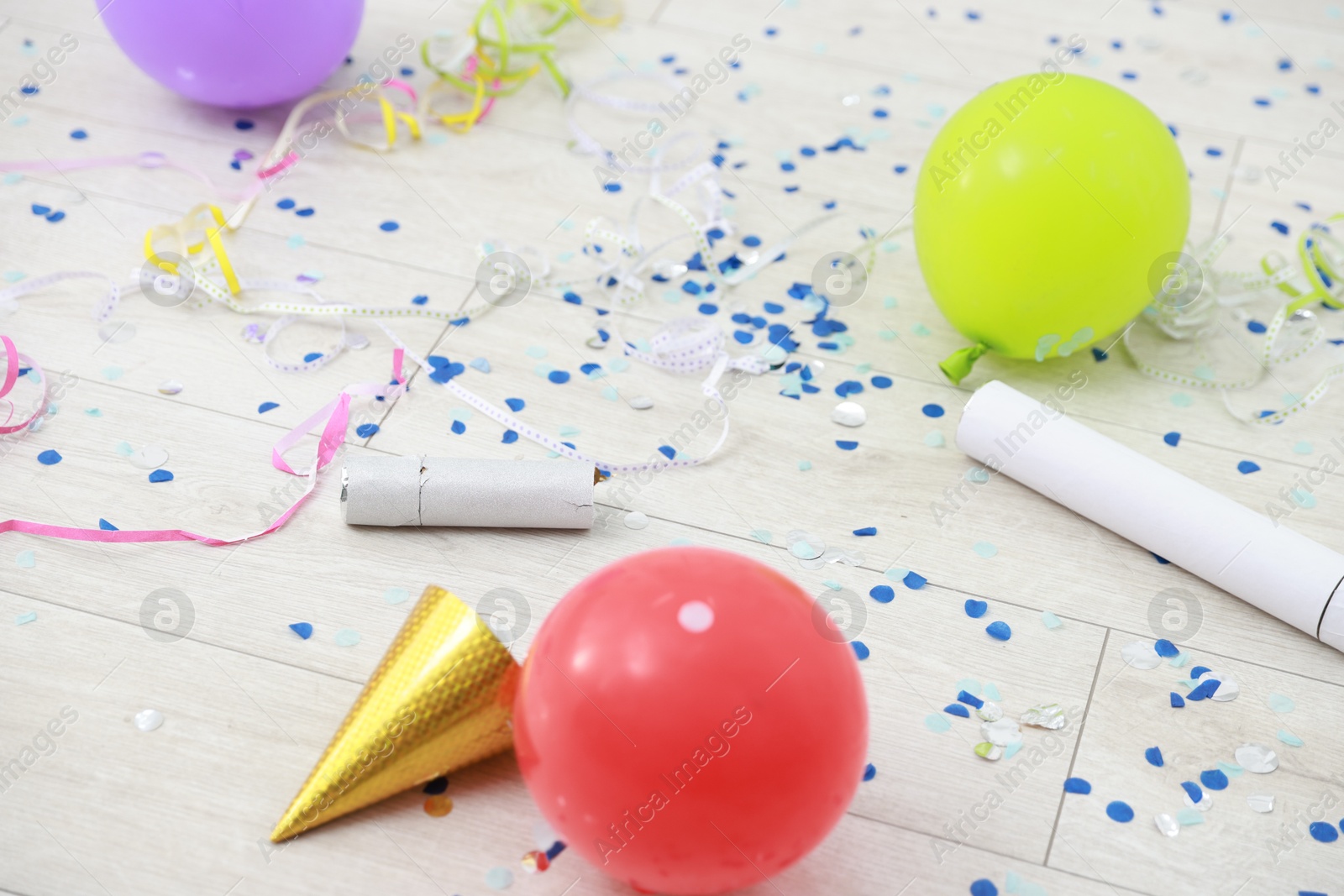 Photo of Confetti poppers, serpentine streamers and other party decor on floor indoors