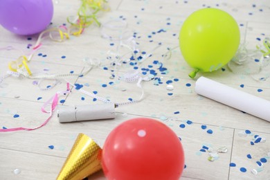 Photo of Confetti poppers, serpentine streamers and other party decor on floor indoors