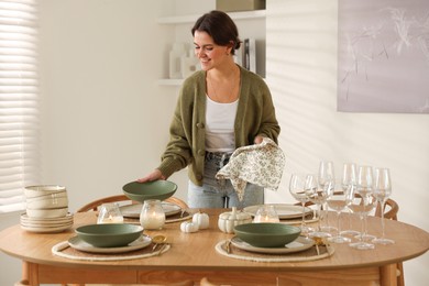 Photo of Woman setting table for dinner at home