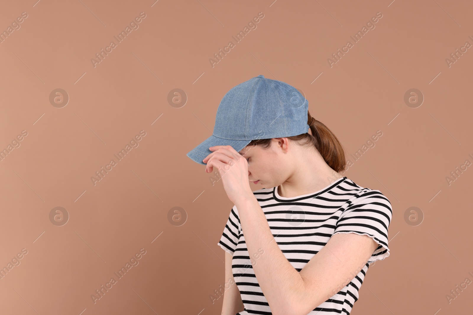 Photo of Woman in stylish baseball cap on beige background. Mockup for design